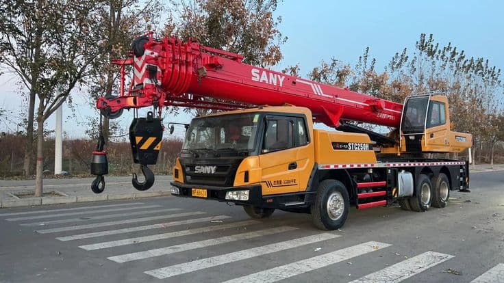 Mobile crane loading heavy material onto a vehicle in Ludhiana